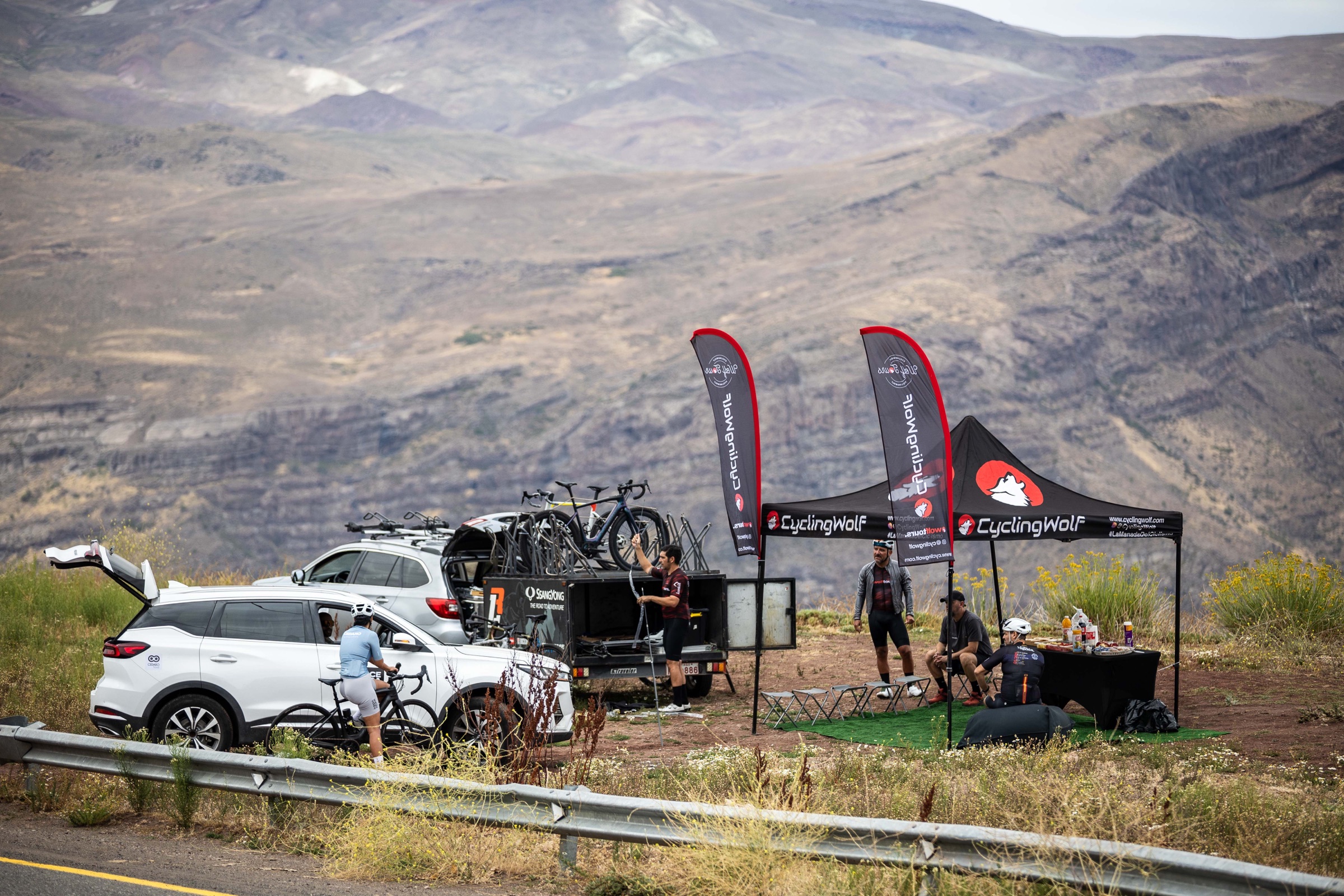 Salida CyclingWolf con autos de apoyo, bicicletas y toldo junto a la cordillera